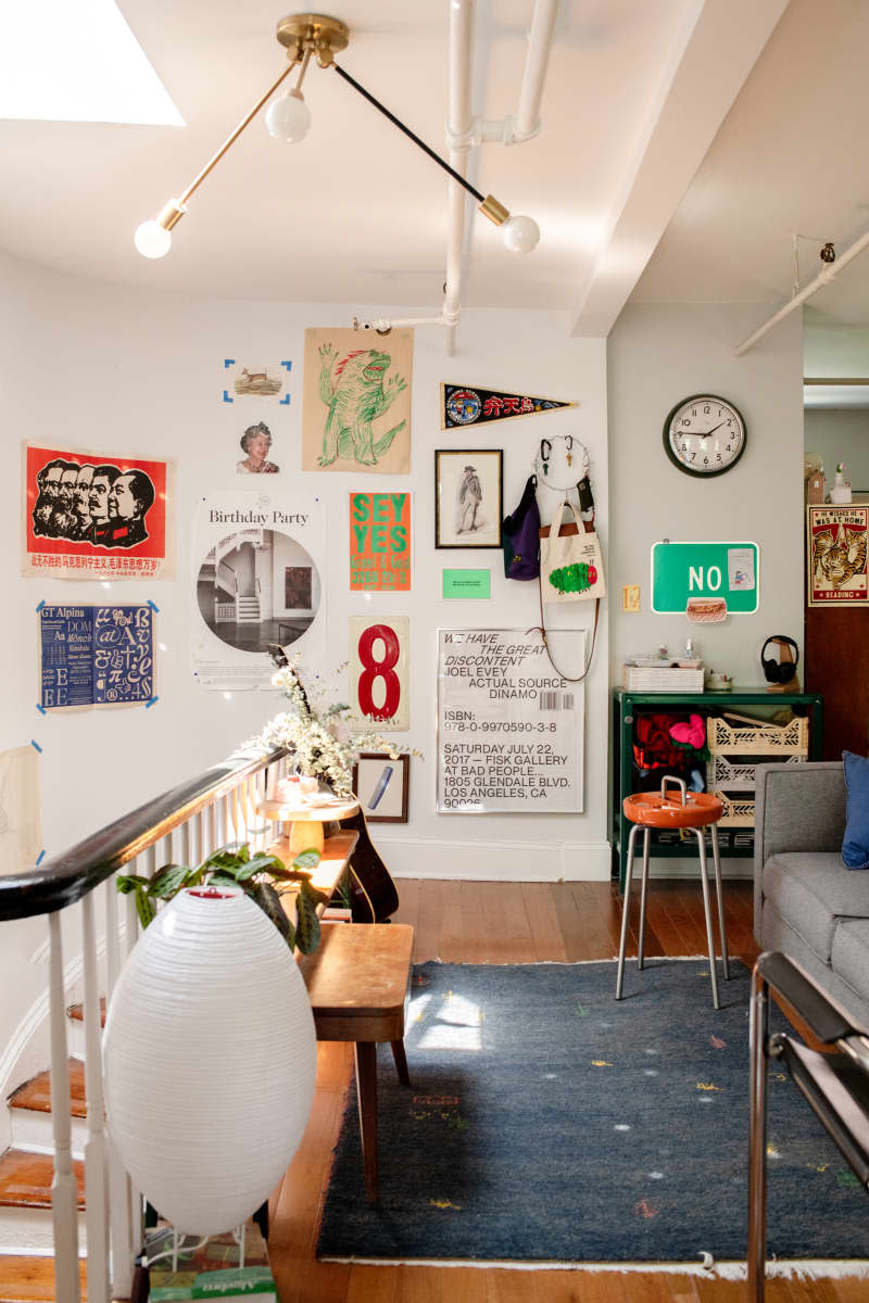 Decorative items are attached to a white wall next to a green cabinet with storage in a stairwell