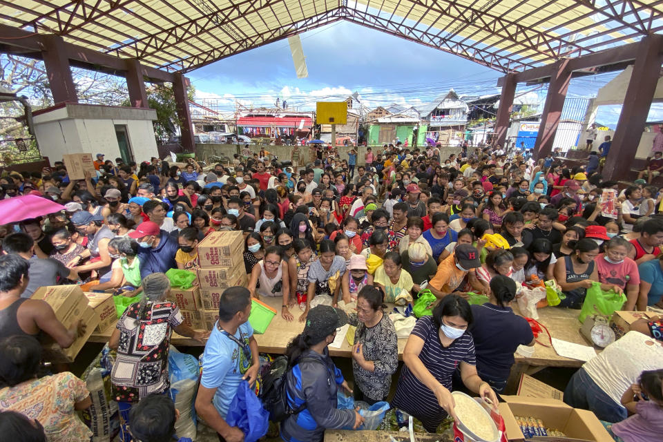 In this photo provided by Greenpeace, residents affected by the onslaught of Typhoon Rai line up for food in San Juan, Surigao City, southern Philippines on Monday Dec. 20, 2021. The governor of a central Philippine province devastated by Typhoon Rai last week pleaded on radio Tuesday for the government to quickly send food and other aid, warning that without outside help, army troops and police forces would have to be deployed to prevent looting amid growing hunger. (Erwin Mascarinas/Greenpeace via AP)