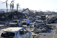 FILE - A man walks through wildfire wreckage Friday, Aug. 11, 2023, in Lahaina, Hawaii. Nearly a month after the deadliest U.S. wildfire in more than a century killed scores of people, authorities on Maui are working their way through a list of the missing that has grown almost as quickly as names have been removed. Lawsuits are piling up in court over liability for the inferno, and businesses across the island are fretting about what the loss of tourism will mean for their futures. (AP Photo/Rick Bowmer, File)