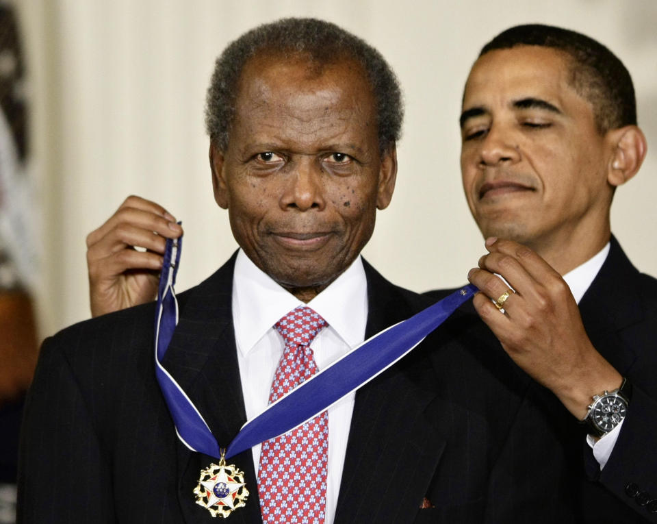 FILE - President Barack Obama, right, presents the 2009 Presidential Medal of Freedom to Sidney Poitier during ceremonies in the East Room at the White House in Washington on Aug. 12, 2009. Among the entertainers who died in 2022 was groundbreaking actor Poitier, who played roles with such dignity that it helped change the way Black people were portrayed on screen. Poitier, who died in January, became the first Black actor to win the Academy Award for Best Actor for his role in the 1963 film “Lilies of the Field." (AP Photo/J. Scott Applewhite, File)