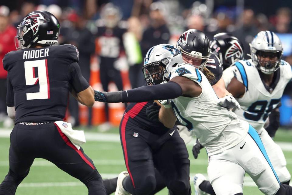 Carolina Panthers linebacker Brian Burns, right, reaches out to strip Atlanta Falcons quarterback Desmond Ridder, left, of the ball during first-quarter action at Mercedes-Benz Stadium in Atlanta, GA on Sunday, September 10, 2023.