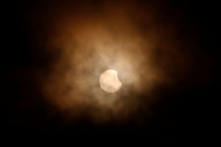 The partial eclipse is obscured by clouds, viewed from the flight deck of the Naval museum ship U.S.S. Yorktown during the Great American Eclipse in Mount Pleasant, South Carolina. REUTERS/Randall Hill