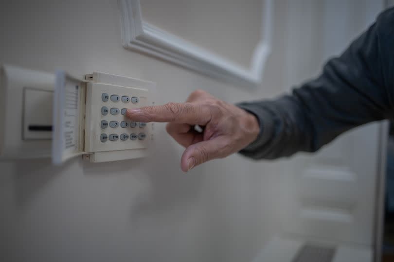 Senior man locking the door with an automated security system