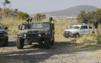 Soldiers stand guard near the site where mass graves were found in Salvatierra, Guanajuato state, Mexico, Thursday, Oct. 29, 2020. A Mexican search group said Wednesday it has found 59 bodies in a series of clandestine burial pits in the north-central state of Guanajuato, and that more could still be excavated. (AP Photo/Mario Armas)