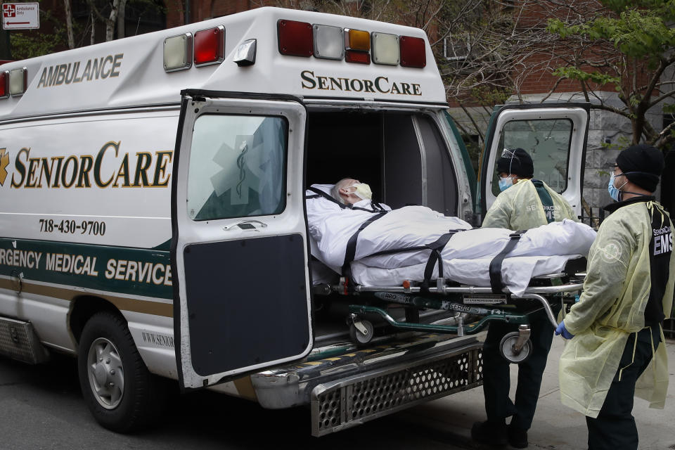 FILE - In this April 17, 2020, file photo, a patient is loaded into an ambulance by emergency medical workers outside Cobble Hill Health Center in the Brooklyn borough of New York. New York state is now reporting more than 1,700 previously undisclosed deaths at nursing homes and adult care facilities as the state faces scrutiny over how it’s protected vulnerable residents during the coronavirus pandemic. (AP Photo/John Minchillo, File)