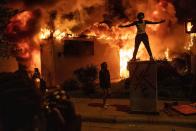 <p>A young man stands in front of a fire during demonstrations near the Minneapolis Police Department’s Fifth Precinct building. </p>