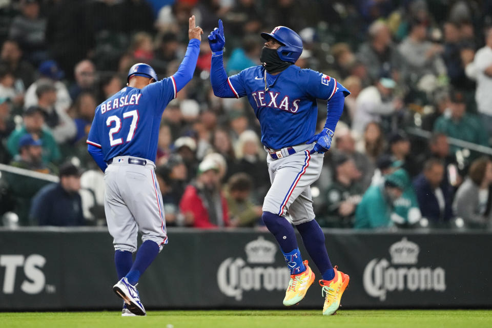 Texas Rangers' Adolis García, right, celebrates his solo home run against the Seattle Mariners with third base coach Tony Beasley (27) during the fourth inning of a baseball game Thursday, Sept. 28, 2023, in Seattle. (AP Photo/Lindsey Wasson)