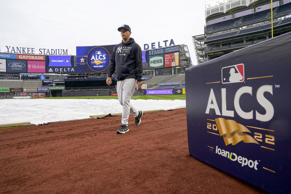 New York Yankees first base coach Travis Chapman walks on the field as a light rain falls before Game 4 of an American League Championship baseball series between the New York Yankees and the Houston Astros, Sunday, Oct. 23, 2022, in New York. (AP Photo/John Minchillo)