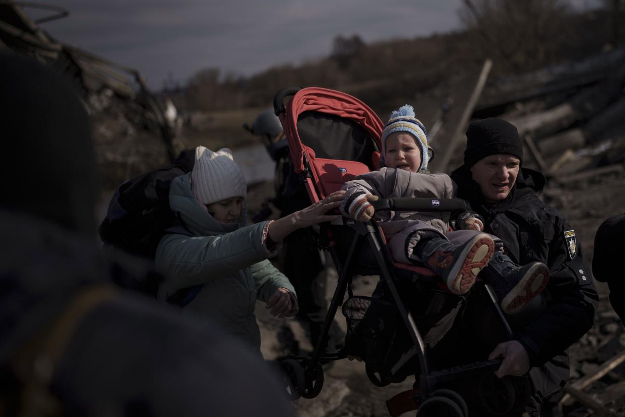 A child is carried on a stroller across an improvised path while fleeing Irpin, on the outskirts of Kyiv, Ukraine, Wednesday, March 9, 2022.