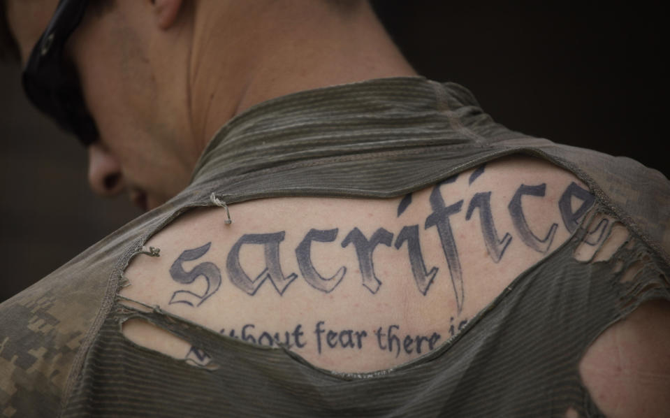 A tattoo on the back of U.S. Army Sgt. James Wilkes of Rochester, N.Y., is seen through his torn shirt after a foot patrol with 1st Platoon, Charlie Company, 2nd Battalion, 1st Infantry Regiment, of the 5th Styker Brigade on May 8, 2010, in Afghanistan's Kandahar province. The full tattoo reads, "Sacrifice. Without fear there is no courage." (AP Photo/Julie Jacobson, File)