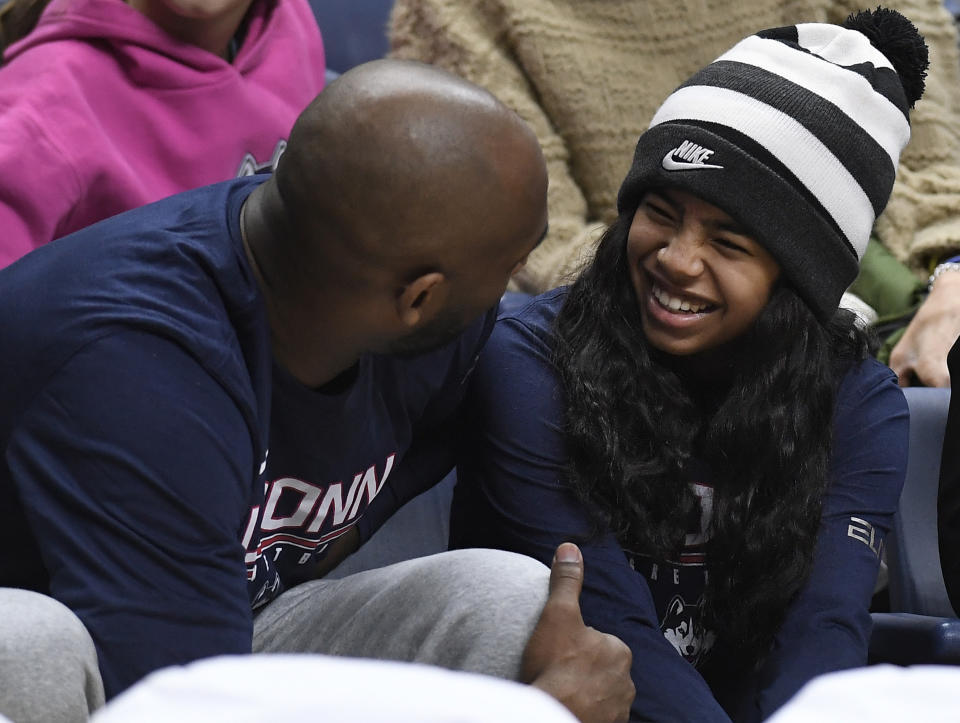 Kobe Bryant and his daughter Gianna watch the first half of an NCAA college basketball game between Connecticut and Houston, Saturday, March 2, 2019, in Storrs, Conn. (AP Photo/Jessica Hill)