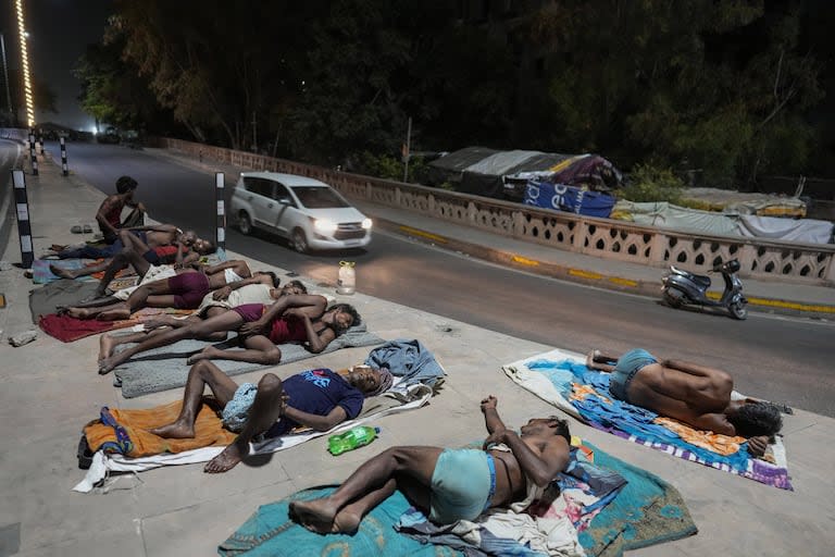 Los trabajadores duermen al lado de una carretera en una noche caliente en Lucknow, India, viernes, 14 de junio de 2024. En los últimos tres meses y medio, la ola de calor que azota desde hace un mes amplias zonas de la India ha causado la muerte de más de 100 personas y ha provocado más de 40.000 casos sospechosos de insolación, según informó el jueves un funcionario del Ministerio de Sanidad.