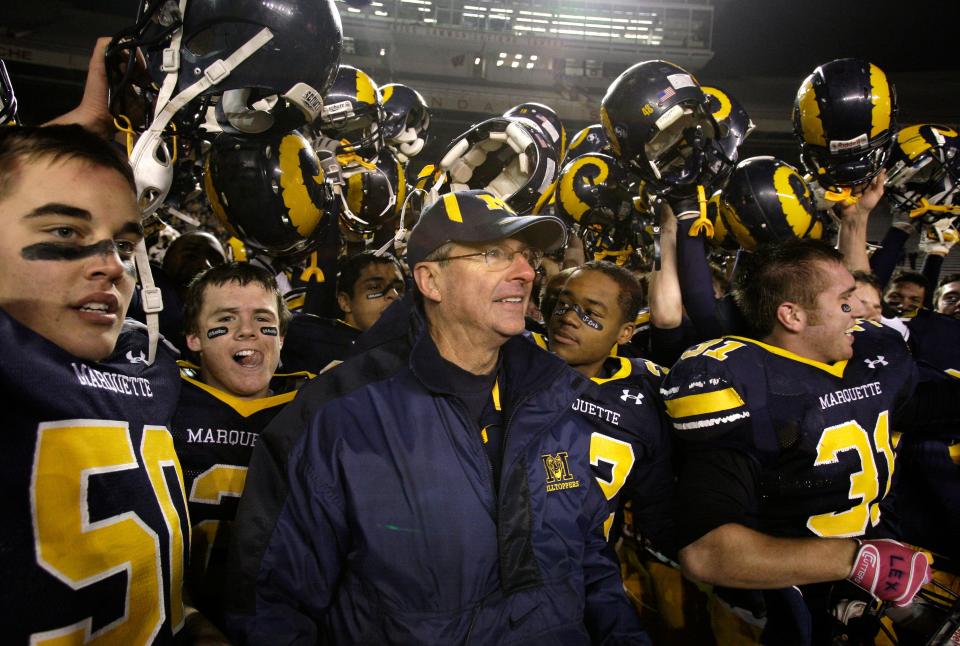Marquette Hilltoppers head coach Dick Basham is surrounded by his jubilant team after beating Menomonee Falls in the Division 1 state final November 20, 2009.