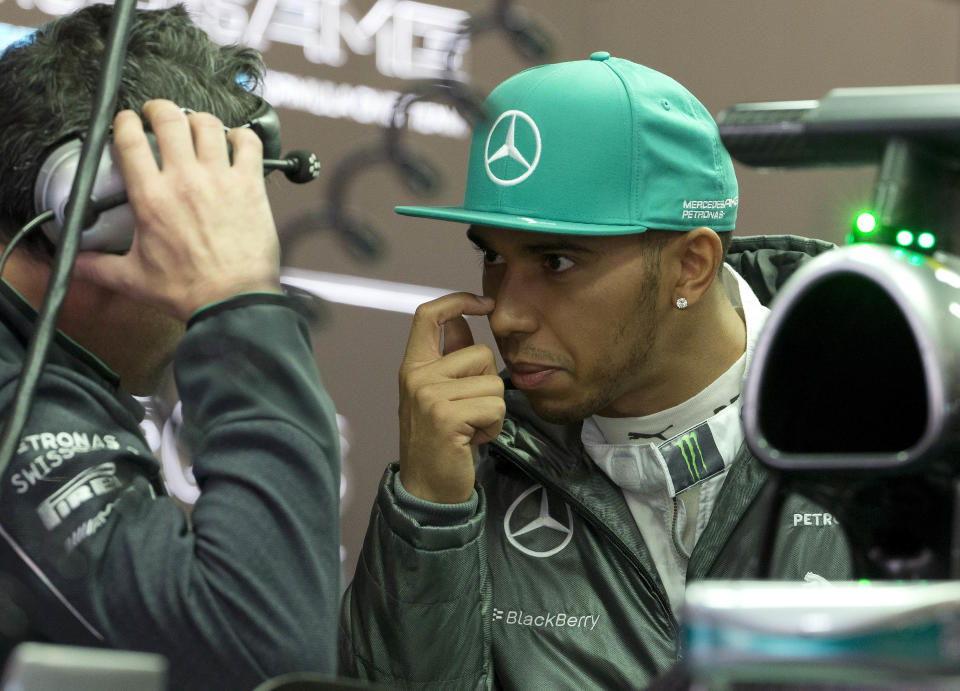 Mercedes driver Lewis Hamilton of Britain chats with his crew inside the garage during the practice session ahead of Sunday's Chinese Formula One Grand Prix at Shanghai International Circuit in Shanghai, China Friday, April 18, 2014. (AP Photo/Andy Wong)