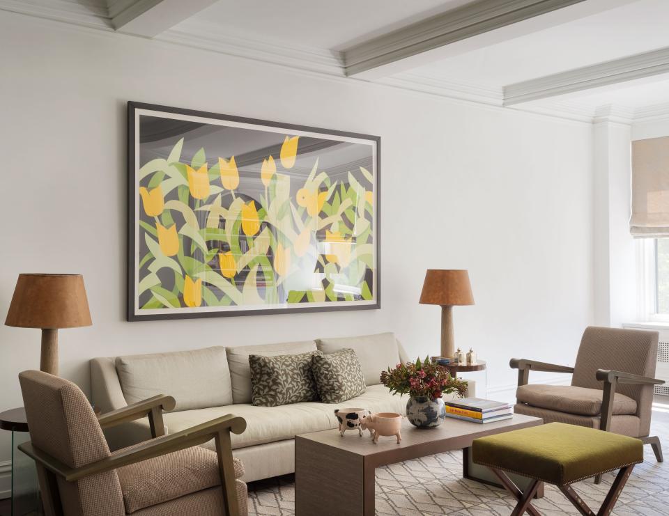 One side of the living room is dominated by a floral piece by Alex Katz, which hangs over a Huniford Collection sofa upholstered in Rogers & Goffigon fabric. The armchairs are custom and covered in Bergamo fabric, the vintage X-bench sports cowhide and mother of pearl inlay, and the lamps are antique French.
