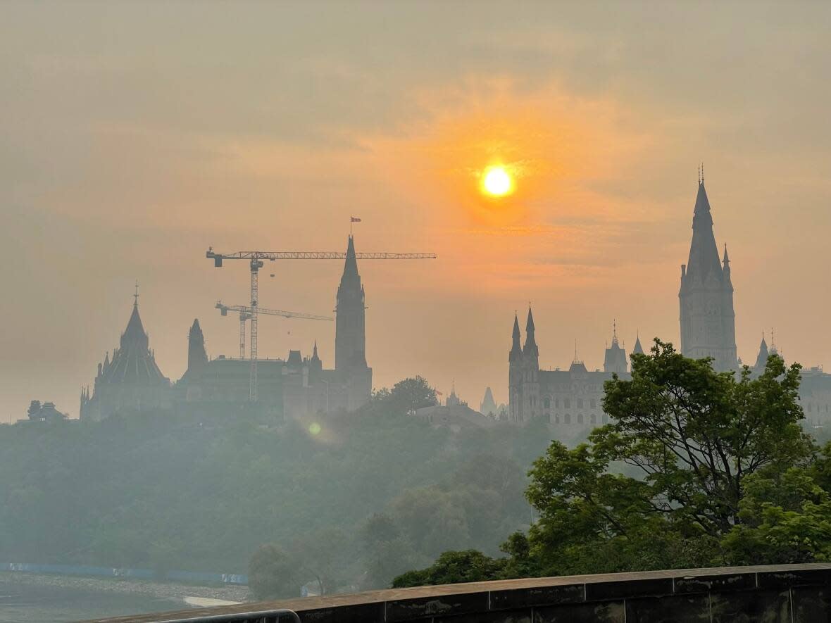 A hazy sunrise over Parliament Hill in Ottawa Wednesday. Air quality is bad in the area because of smoke from wildfires to its west and north. (Matéo Garcia-Tremblay/Radio-Canada - image credit)