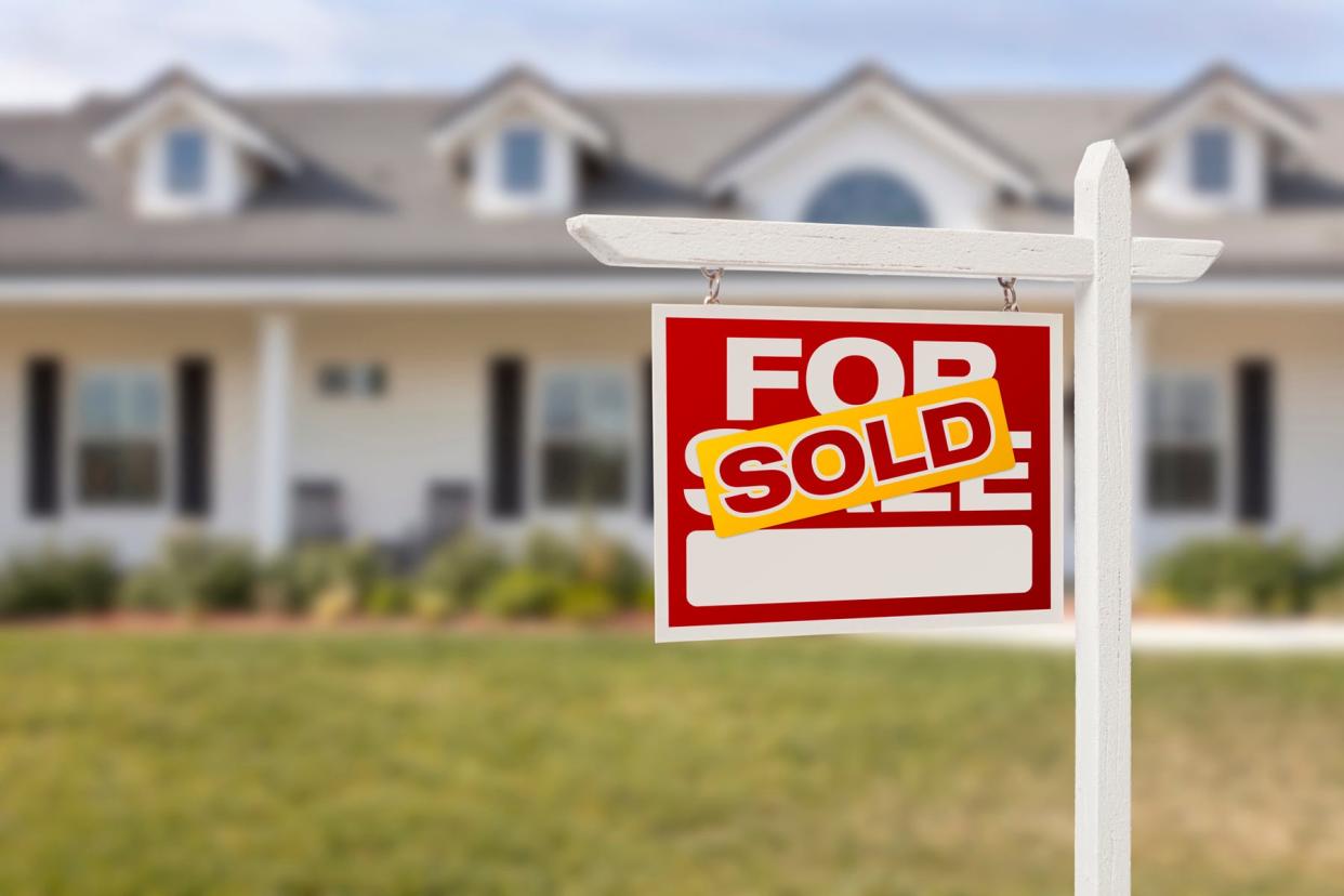 Red Sold For Sale Real Estate Sign in Front of House.