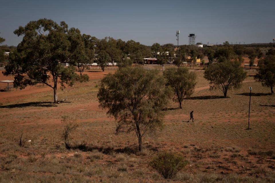 A man walks across a park towards town in Hermannsburg, near Areyonga (Reuters)