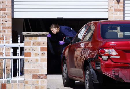 A member of the Australian Federal Police (AFP) forensic unit inspects a garage at a house that was involved in pre-dawn raids in the western Sydney suburb of Guilford September 18, 2014. REUTERS/David Gray