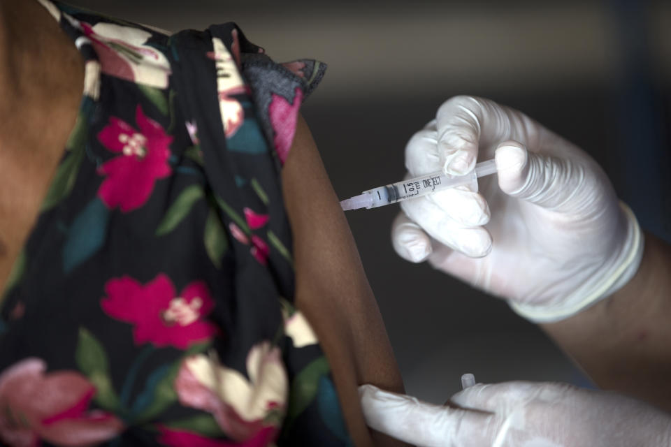 A health worker administers a Moderna COVID-19 booster shot to an elderly woman during a third dose vaccination campaign in Denpasar, Bali, Indonesia Saturday, Jan. 29, 2022. (AP Photo/Firdia Lisnawati)