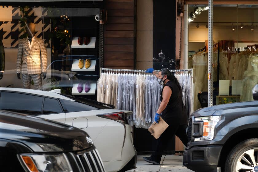 LOS ANGELES, CA - APRIL 11: A rack of clothes are rolled to its destination in the Fashion District of Los Angeles. A new downtown plan will, among many things, rezone large areas of the garment district to allow residential development. Garment industry leaders are concerned about the effect on their businesses. Photographed on Tuesday, April 11, 2023 in Los Angeles, CA. (Myung J. Chun / Los Angeles Times)