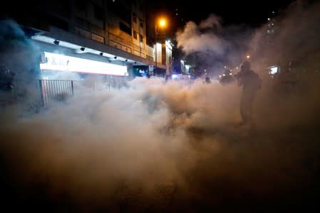 A man is seen after riot police fired tear gas after a sit-in at Yuen Long to protest against violence that happened two months ago when white-shirted men wielding pipes and clubs wounded both anti-government protesters and passers-by, in Hong Kong