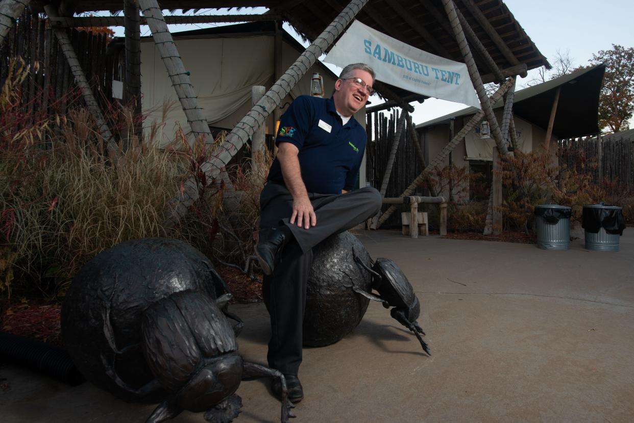 Sitting on sculpted dung beetles Tuesday afternoon, outgoing Topeka Zoo CEO Brendan Wiley laughs about some of the clever elements paying homage to past director Gary Clarke incorporated throughout Camp Cowabunga.
