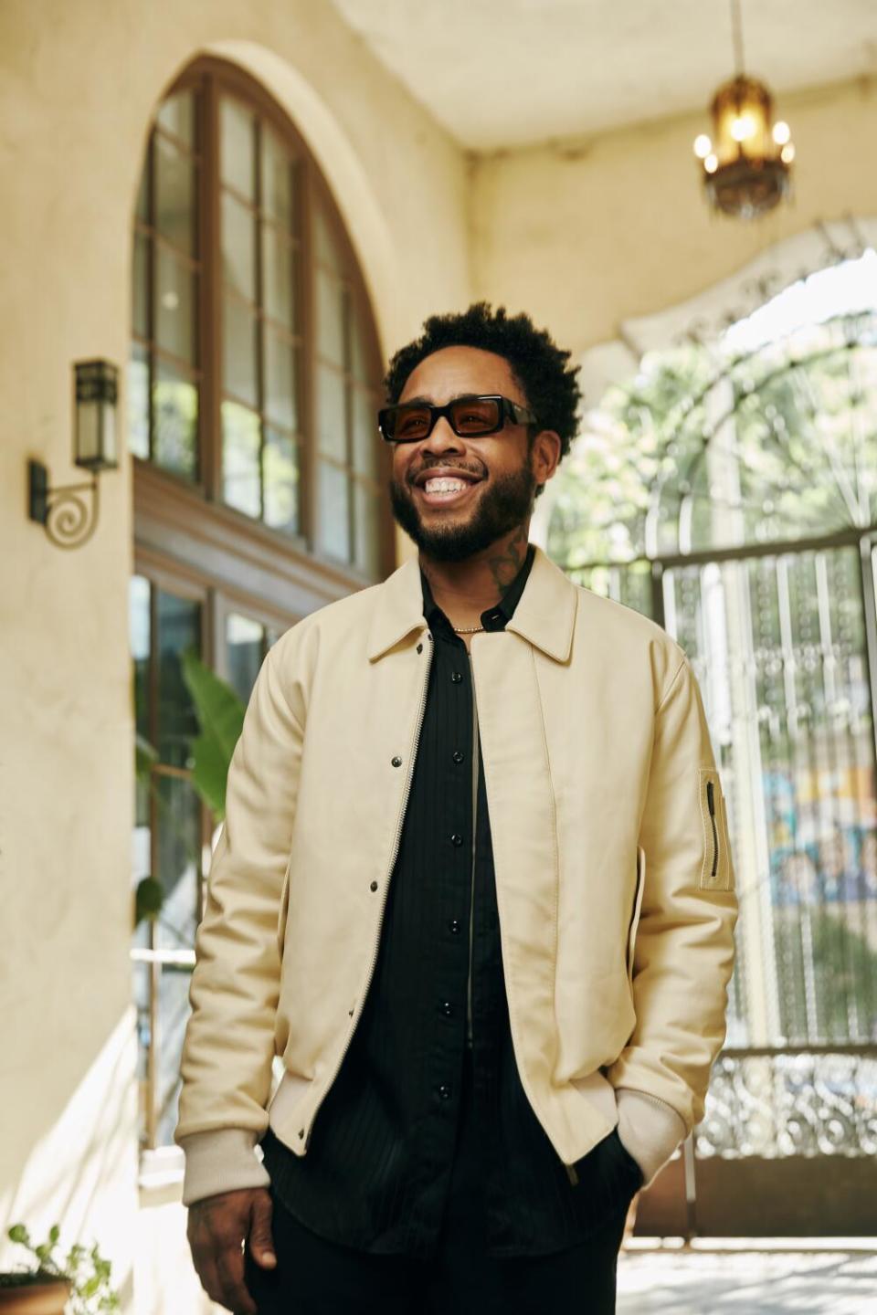 Terrace Martin, wearing sunglasses, smiles.