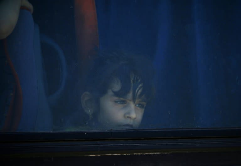 A Syrian girl looks out of a bus window during the evacuation of rebels and their families from Daraa city on July 15, 2018