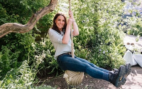 The Duchess of Cambridge tries the swing during a working visit to the garden earlier this week - Credit: Kensington Palace