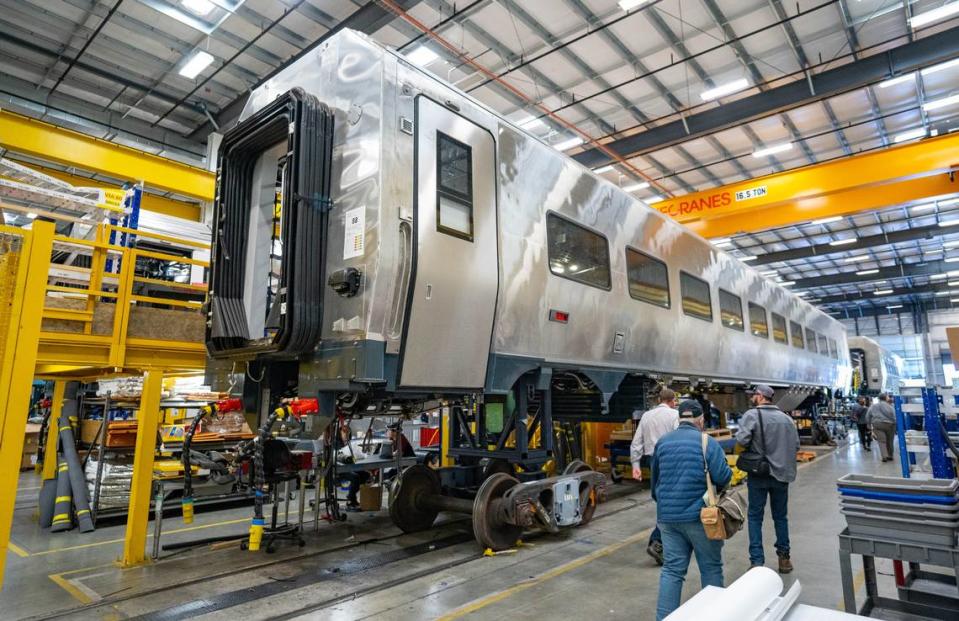 People walk by an unfinished Amtrak Airo car during a tour of the Siemens manufacturing facility on in October. The company plans to start delivering 87 train sets to the passenger service by the end 2024. Cameron Clark/cclark@sacbee.com