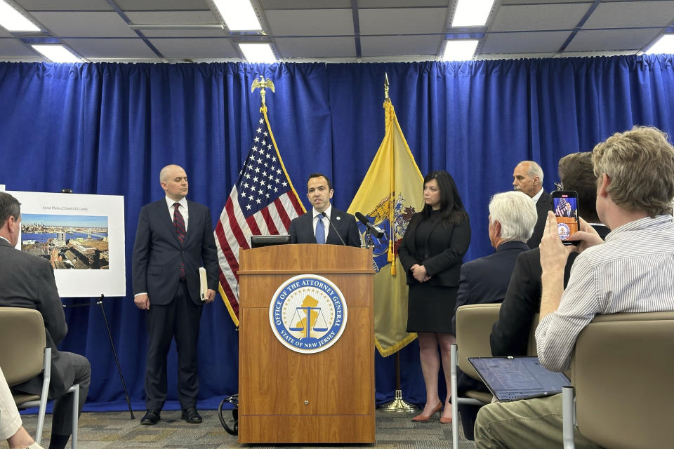 New Jersey Attorney General Matt Platkin, center, discusses racketeering and other charges against influential Democratic power broker George Norcross, sitting in the front row, right, with white hair, Monday, June 17, 2024, in Trenton, N.J. (AP Photo/Mike Catalini)