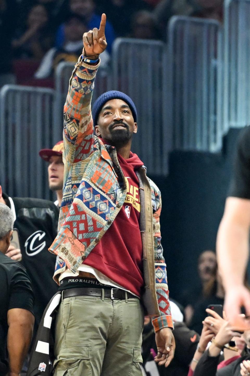 Former NBA player J.R. Smith waves to the crowd during the first half of an NBA basketball game between the Dallas Mavericks and the Cleveland Cavaliers, Saturday, Dec. 17, 2022, in Cleveland. (AP Photo/Nick Cammett)