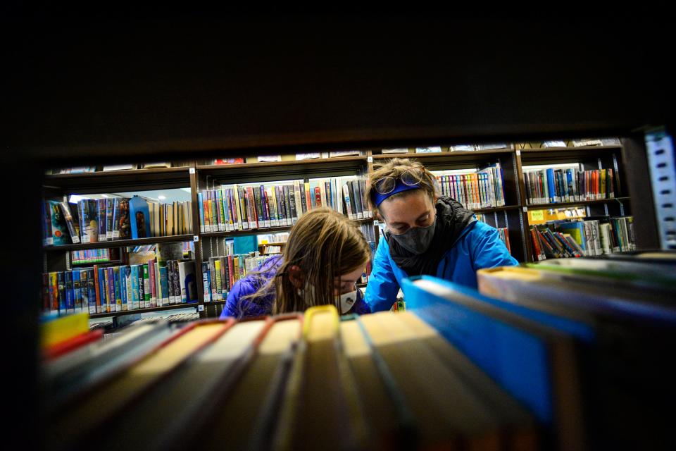 Beatrix Robb, 13, of Brattleboro, Vermont, and her mother, Jen, look for a book at the Brooks Memorial Library, in Brattleboro Nov. 13, 2020.