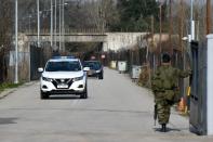 A Greek soldier opens the gate to a police vehicle, at the closed Kastanies border crossing with Turkey's Pazarkule, in the region of Evros