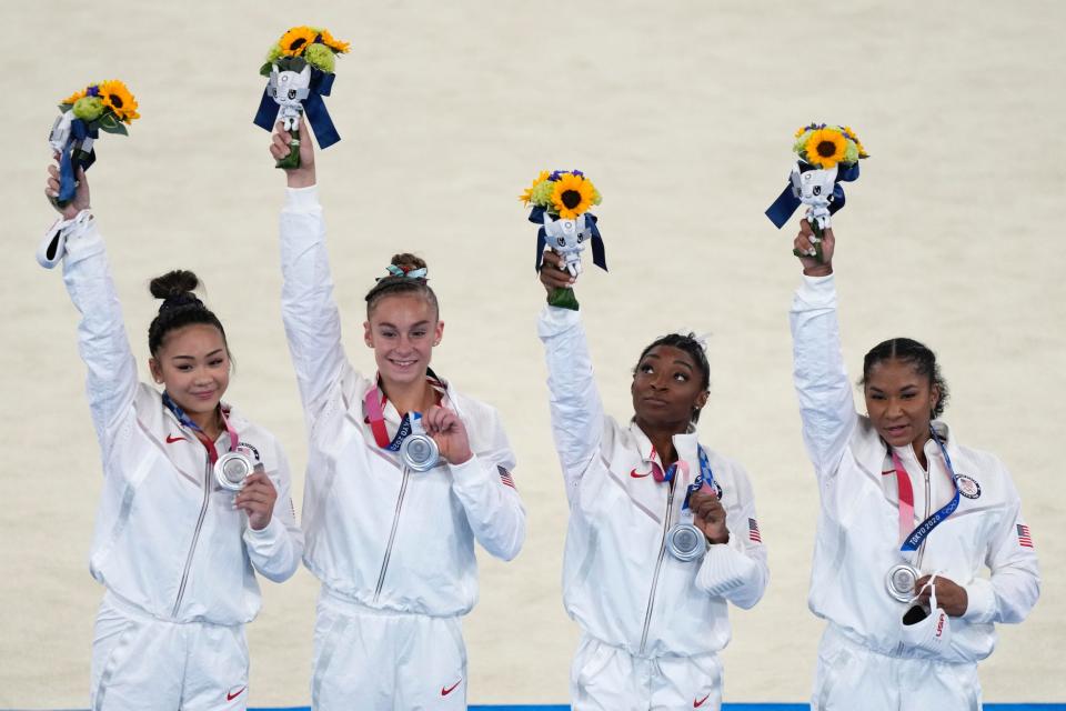 Simone Biles and Team USA pose with their silver medals from the team all-around competition.