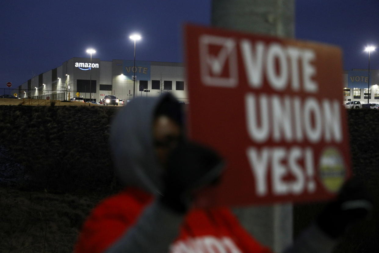 A person affiliated with RWDSU (Retail, Wholesale and Department Store Union) holds a sign supporting unionization in front of an Amazon facility on the first day of the unionization vote in Bessemer,  Alabama, U.S., February 4, 2022. REUTERS/Dustin Chambers