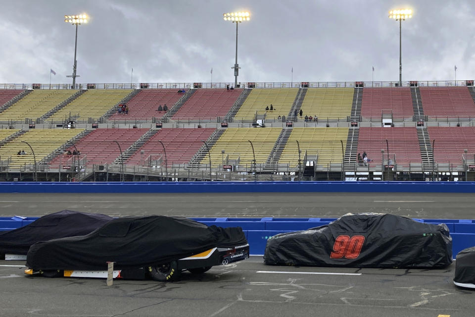Covered race cars from the NASCAR Xfinity Series sit parked on pit road during a rain delay before the start of the race in Fontana, Calif., Saturday, Feb. 25, 2023. NASCAR has canceled practice and qualifying sessions for the weekend races at Fontana because of ongoing heavy rains. (AP Photo/Greg Beacham)