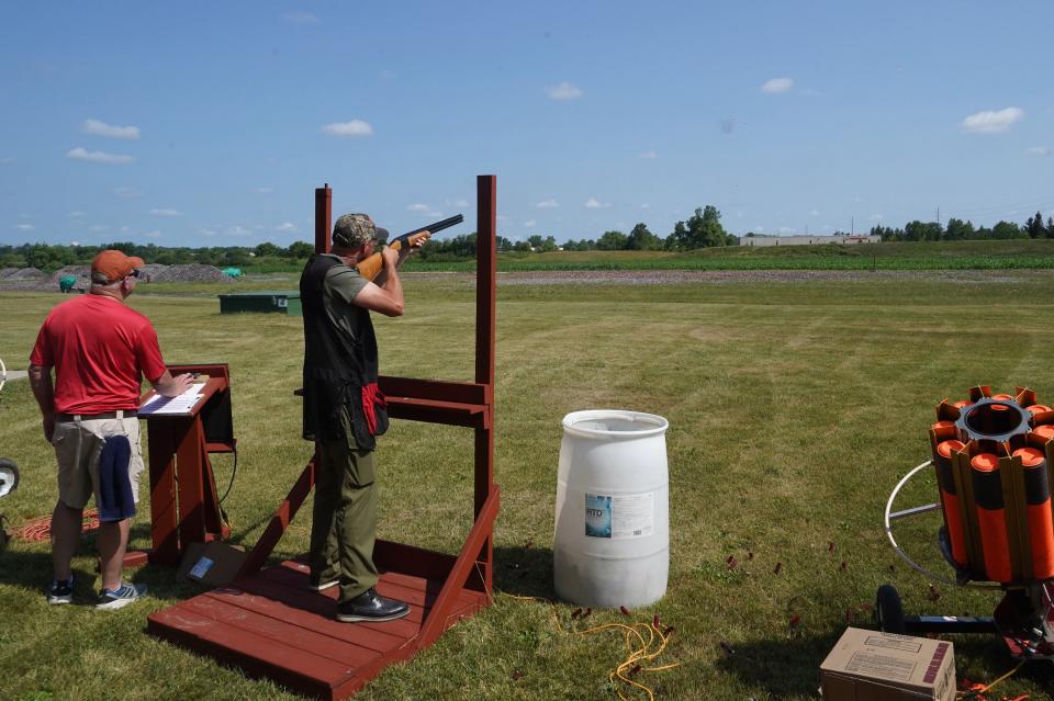 Chad Johnson of Jackson breaks a clay pigeon while target thrower John Marose of Waukesha looks on at Christopher's Shoot Against Childhood Cancer at Waukesha Gun Club.