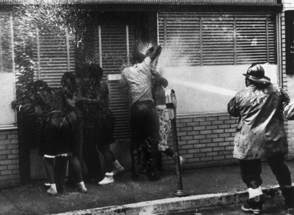 A firefighter sprays people with a high-pressure hose as they protest segregation in Birmingham, Alabama, in May 1963. (Photo: Bettmann/Getty Images)