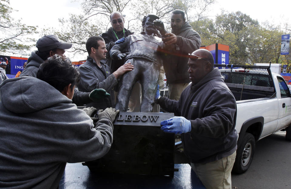 The bronze sculpture of Fred Lebow, the founder of the New York City Marathon, is unloaded by members of the Central Park Conservancy at the marathon finish line, in New York's Central Park, Friday, Nov. 2, 2012. The course for Sunday's New York City Marathon will be the same since there was little damage but getting to the finish line could still be an adventure for runners from outlying areas. Such is life in Sandy's aftermath disrupted trains, planes, buses and ferries, flooded buildings, blocked roads and knocked out power. (AP Photo/Richard Drew)