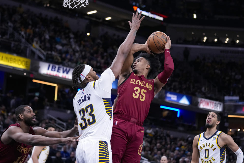 Indiana Pacers center Myles Turner (33) goes up to block the shot of Cleveland Cavaliers forward Isaac Okoro (35) during the first half of an NBA basketball game in Indianapolis, Monday, March 18, 2024. (AP Photo/Michael Conroy)