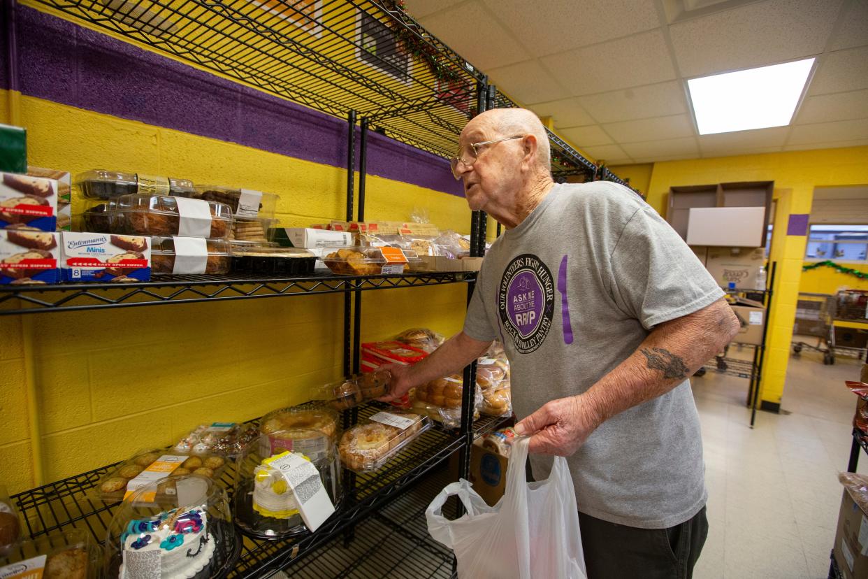 Junior Foster grabs muffins for a food order on Wednesday, Dec. 14, 2022, at the Rock River Valley Food Pantry in Rockford.