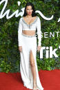<p>in a white two-piece with crystal embellishments and a thigh-high slit. </p>
