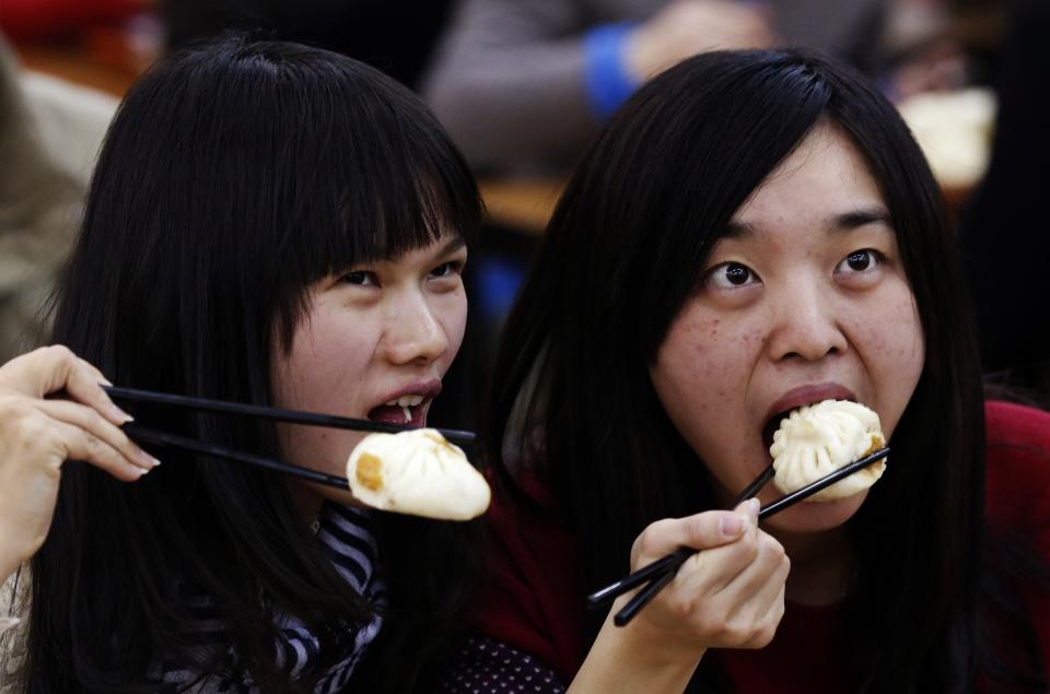 Diners pose for pictures with steamed buns which Chinese President Xi ate, at the Qing-Feng steamed buns restaurant in Beijing