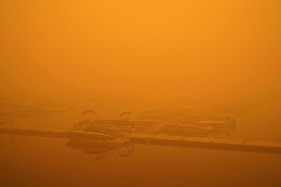 Boats are partially obscured by smoke from a wildfire at a marina on Detroit Lake burned by the Beachie Creek Fire, Saturday, Sept. 12, 2020, in Detroit, Ore. (AP Photo/John Locher)