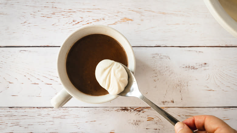 Adding whipped cream to hot chocolate mug
