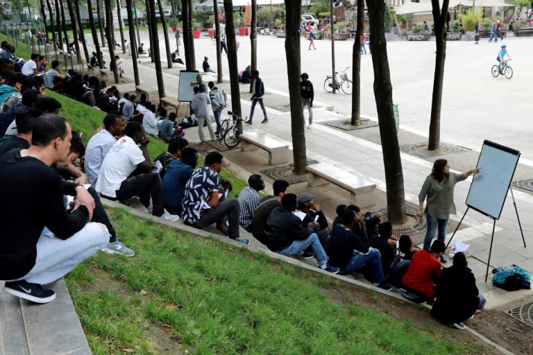 A volunteer delivers a French language class near Place de Stalingrad in Paris for migrants mainly from Sudan and Afghanistan