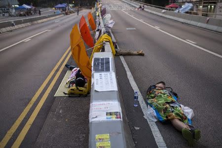 Protesters of the Occupy Central movement sleep on a main road leading to the financial Central district being blocked at dawn, in Hong Kong October 7, 2014. REUTERS/Tyrone Siu