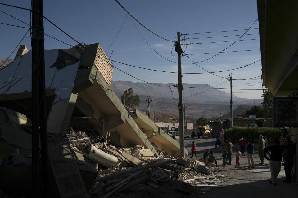 <p>People walk next to a destroyed house after an earthquake in the city of Darbandikhan, northern Iraq, Monday, Nov. 13, 2017. (Photo: Felipe Dana/AP) </p>